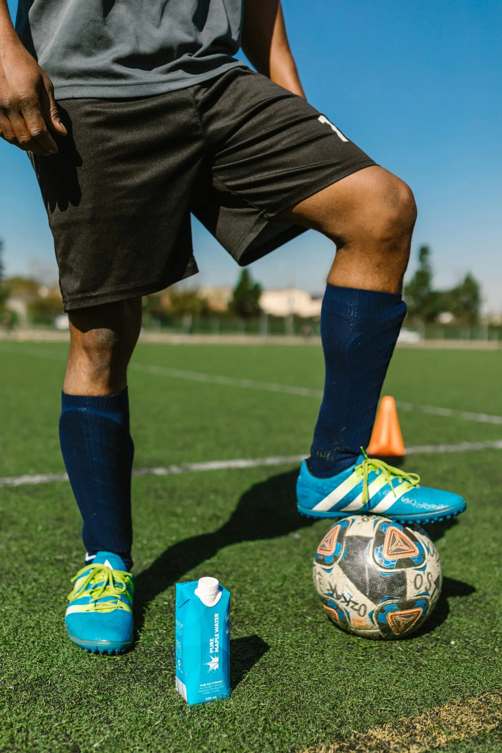 A man stands adjacent to a soccer ball, poised for action on the soccer field
