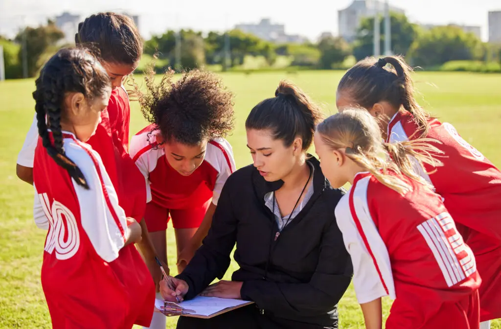 female youth soccer coach and her young team.